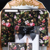 A set of floral-themed stationery, including a folder, bow-tied notepad, and a note sheet with a rose gold pen, arranged on a decorative tray.