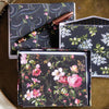 A collection of floral-themed stationery with envelopes and notecards, accompanied by a floral-patterned pen, all set on a gold surface.