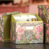 A floral-patterned box with a label holder sits open, revealing neatly organized index cards inside. The lid is propped open, and the background includes another similar box.