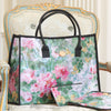 A floral-patterned handbag with black handles and a matching small pouch rests on an ornate armchair.