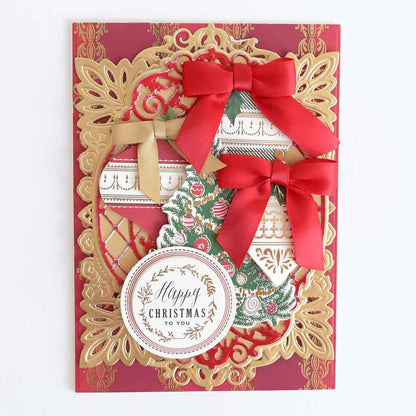 A Reason for the Season Sticker Bundle layered holiday card with gold die-cut flourishes, a Christmas tree, two red ribbon bows, and a circular tag reading “Happy Christmas to you.”