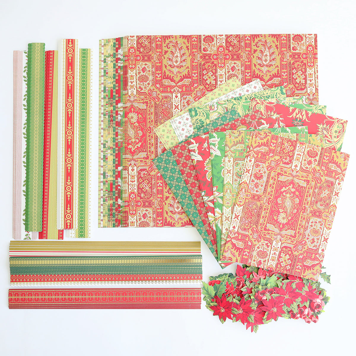 Papers, strips, and poinsettia cutouts from the Jasmine Holiday Papercrafting Kit are arranged neatly on a white surface, showcasing festive Christmas-themed embellishments and patterned cardstock perfect for all your seasonal crafting projects.