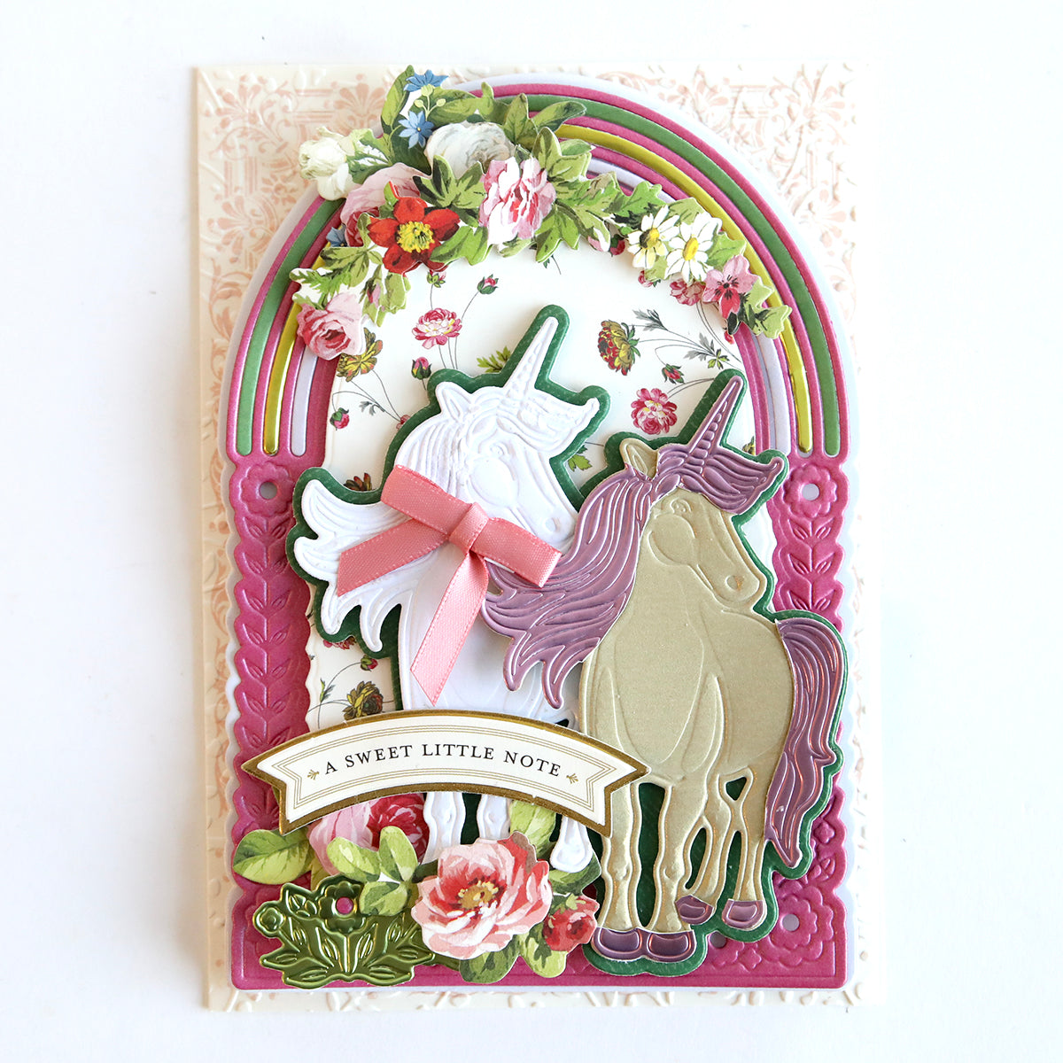 Handmade greeting card featuring 3D Unicorn Scene Dies and floral motifs with a pastel color palette and a ribbon, accompanied by the text "a sweet little note" created using the Anna Griffin Empress Machine.