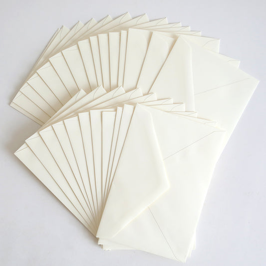 A fan-shaped arrangement of 25 Pack Natural Envelope 8.125" x 5.5" displayed on a white surface.