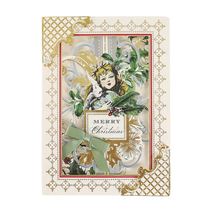 Handcrafted Christmas Engravings Cards and Envelopes featuring a vintage angel illustration, gold detailing, green ribbon, holly accents, and “Merry Christmas” text on a decorative ornate background—perfect for Anna Griffin enthusiasts and anyone who loves elegant Christmas card making.