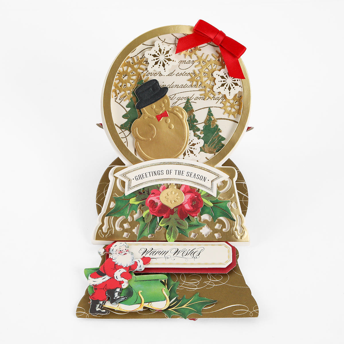 Handmade holiday card featuring gold accents, holly leaves, and a “Greetings of the Season” message with a Santa Claus illustration on a green bench—ideal for crafting enthusiasts and perfectly designed to coordinate with your favorite metal dies or the Snowglobe Easel Card Dies.