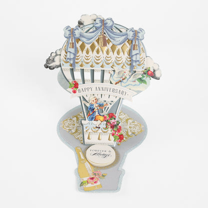 Pop-up card crafted with the Hot Air Balloon Easel Die, featuring a hot air balloon shape, “Happy Anniversary” sentiment, delicate floral accents, a champagne bottle detail, and a “Forever & Always” label on a clean white background—an enchanting creation to elevate any handmade card collection.