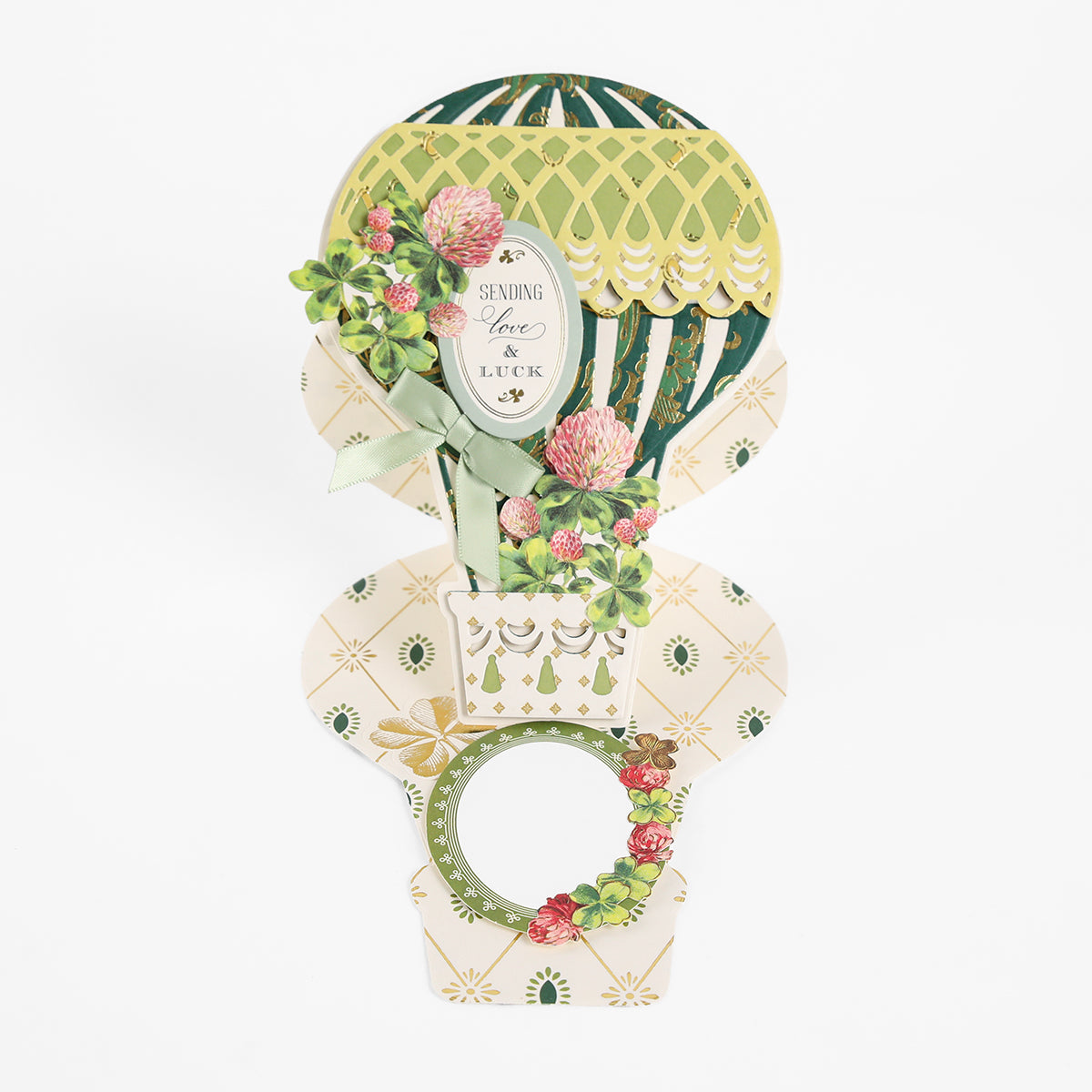 Crafted with the Hot Air Balloon Easel Die, this handmade pop-up greeting card showcases a hot air balloon adorned with elegant floral patterns. The pristine white background highlights the heartfelt message “Sending Love & Luck.”.