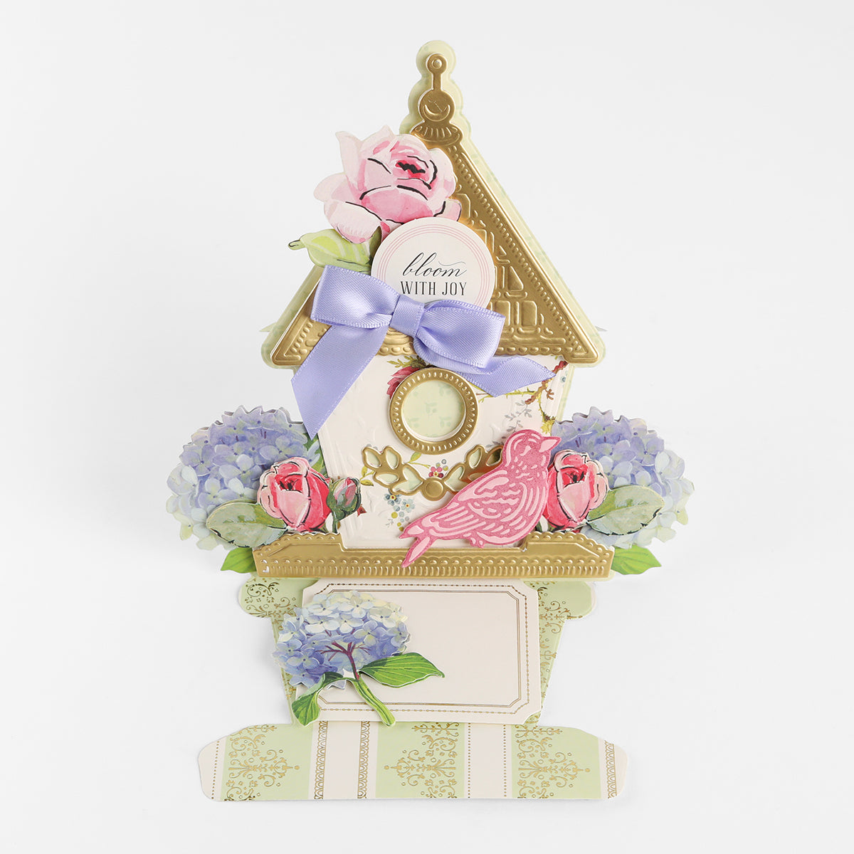 Created with the Birdhouse Easel Card Dies, this decorative card is shaped like a charming birdhouse and beautifully embellished with flowers, a purple bow, a gold roof, and a pink bird. The sentiment “Bloom with joy” appears near the top—making it an ideal choice for housewarming gifts or brightening any special occasion.