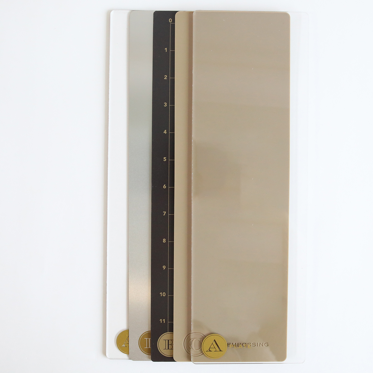 Four rectangular color and measurement samples with numbers and gold labels, made using the Empress Elite Mini Machine with 5" x 10" and 13" Plates, are stacked side by side on a white background.