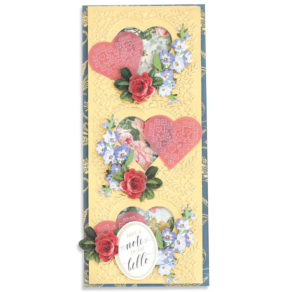 Using the Slimline Hearts Dies and Cut Emboss Folders, a decorative card features three heart cutouts adorned with intricate rose designs and blue flowers. At the bottom, it beautifully displays the message "Just a note to say hello" within an oval frame.