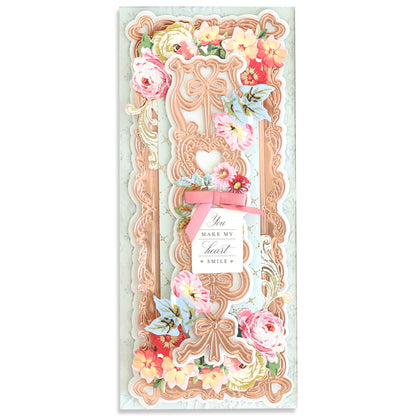 An exquisite card embellished with pink and orange flowers, intricate patterns, and a pink bow showcases the elegance of the Slimline Hearts Dies and Cut Emboss Folders. Delicate hearts accentuate the corners, while a central message reads, "You make my heart smile.