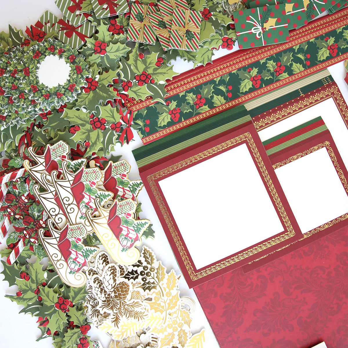 A collection of Simply Noel Papers and Embellishments, including patterned papers, decorative borders, double sided cardstock, cut-out holly, journaling tags, ribbons, and holiday designs arranged on a white surface.