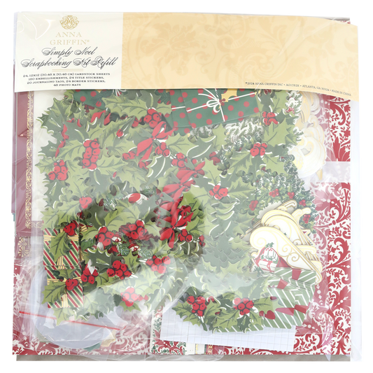 A package of Simply Noel Papers and Embellishments, including holly designs, ornaments, and double-sided cardstock in festive colors. The clear packaging features an ornate gold label at the top.