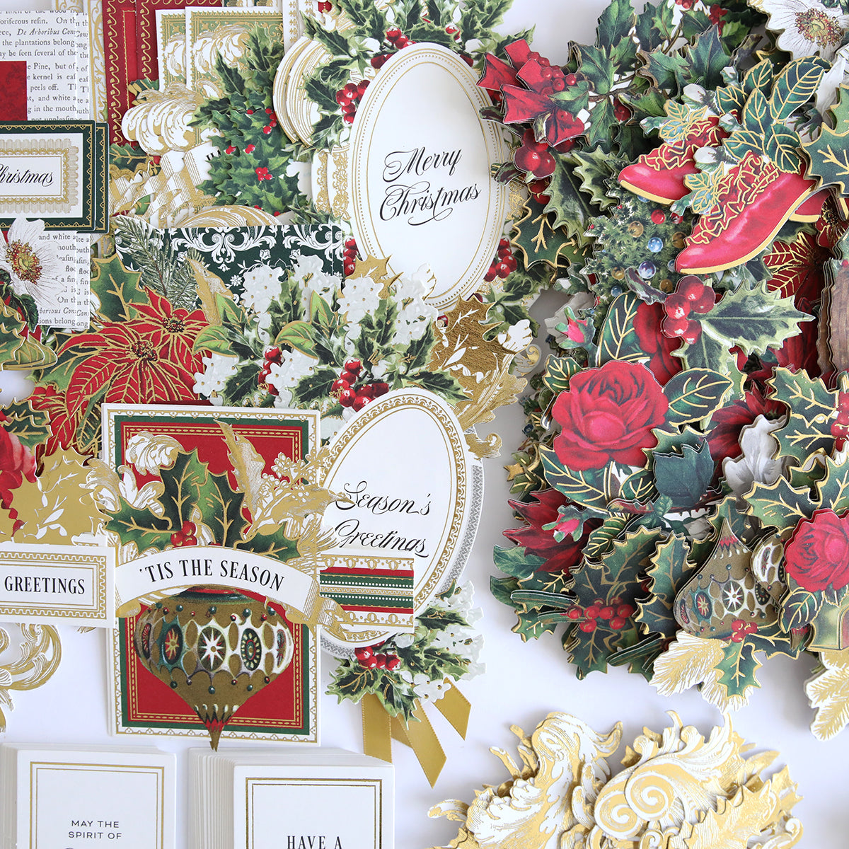 A variety of ornate Christmas cards adorned with festive designs and messages such as "Merry Christmas" and "Season’s Greetings," featuring red roses, holly, ribbons, and gold embellishments. Perfect for the Christmas Greetings Refill Kit, these cards come with collage card toppers for a creative touch.