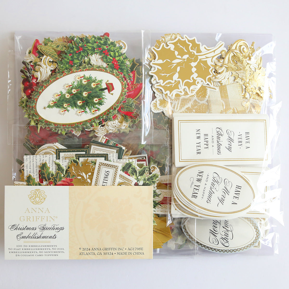 A collection of Anna Griffin decorative Christmas embellishments from the Christmas Greetings Refill Kit, including Collage Card Toppers, holiday-themed cutouts, labels, and tags in festive colors and designs, all packaged in a clear plastic bag.