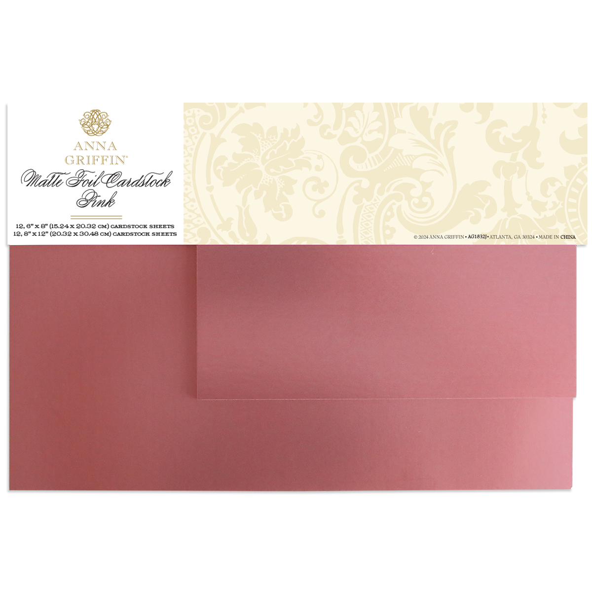 Two sheets of Luxury Matte Foil Cardstock Pink, partially overlapping and topped with a decorative Anna Griffin label, perfect for diecutting and embossing projects.