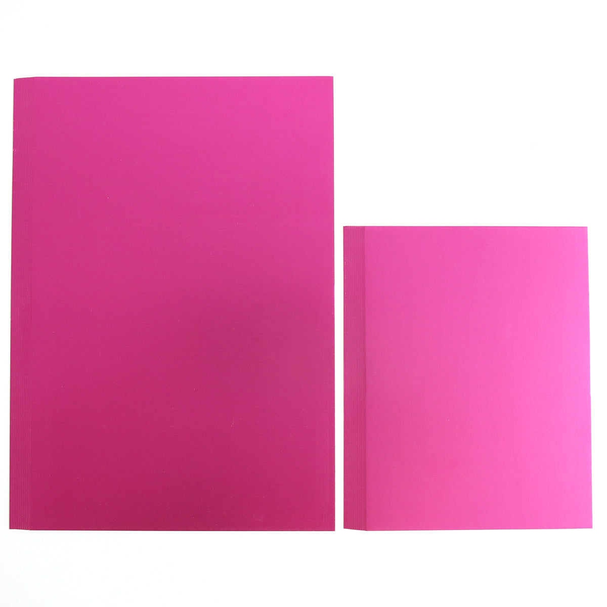 Two closed, plain books of different sizes—made from Luxury Matte Foil Cardstock Bright Pink—are placed side by side on a white background.