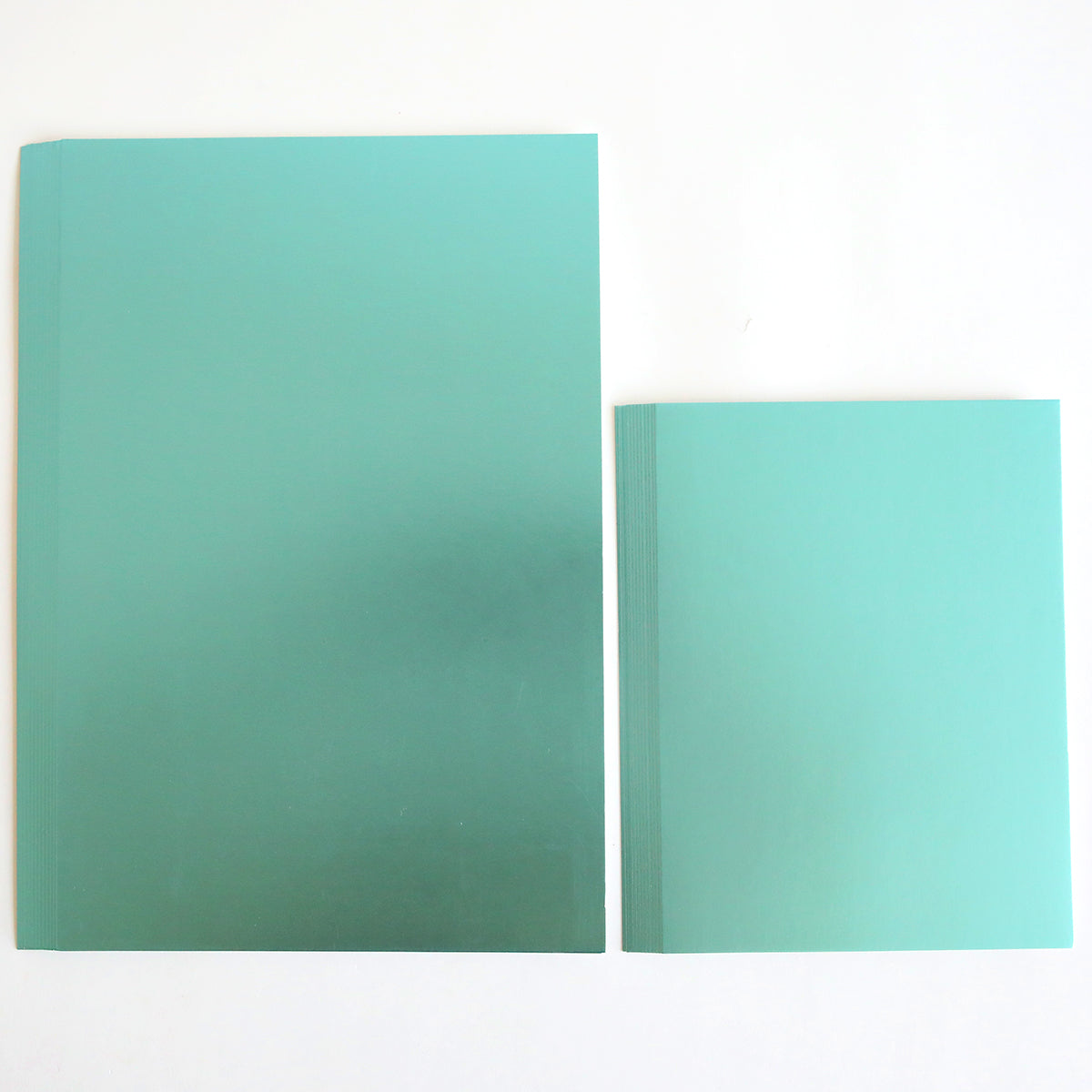 Two Luxury Matte Foil Cardstock Blue notebooks on a white background, precisely die-cut. The larger one on the left and the smaller on the right form an elegant pair.