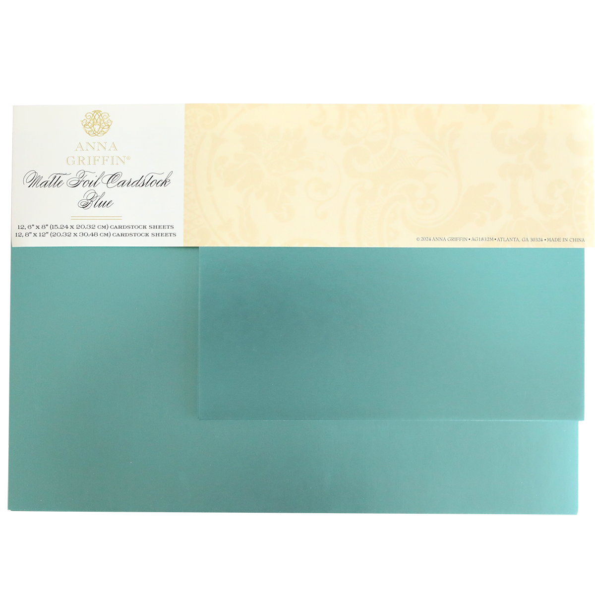 The Luxury Matte Foil Cardstock Blue by Anna Griffin, featuring a decorative beige label with text and floral patterns, is perfect for embossing and die-cutting.