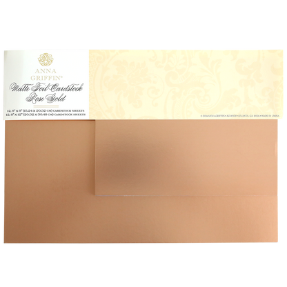 Two sheets of Luxury Matte Foil Cardstock Rose Gold partially overlap, featuring a decorative Anna Griffin label on the top left—ideal for embossing or die-cutting elegant crafts.