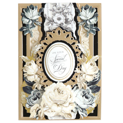 A decorative greeting card featuring white and black ornate floral designs with an oval frame in the center that reads "On Your Special Day," enhanced with Black and Cream Flower Stickers for added charm. Perfect for adding to your scrapbook pages or as embellishment stickers on gifts.