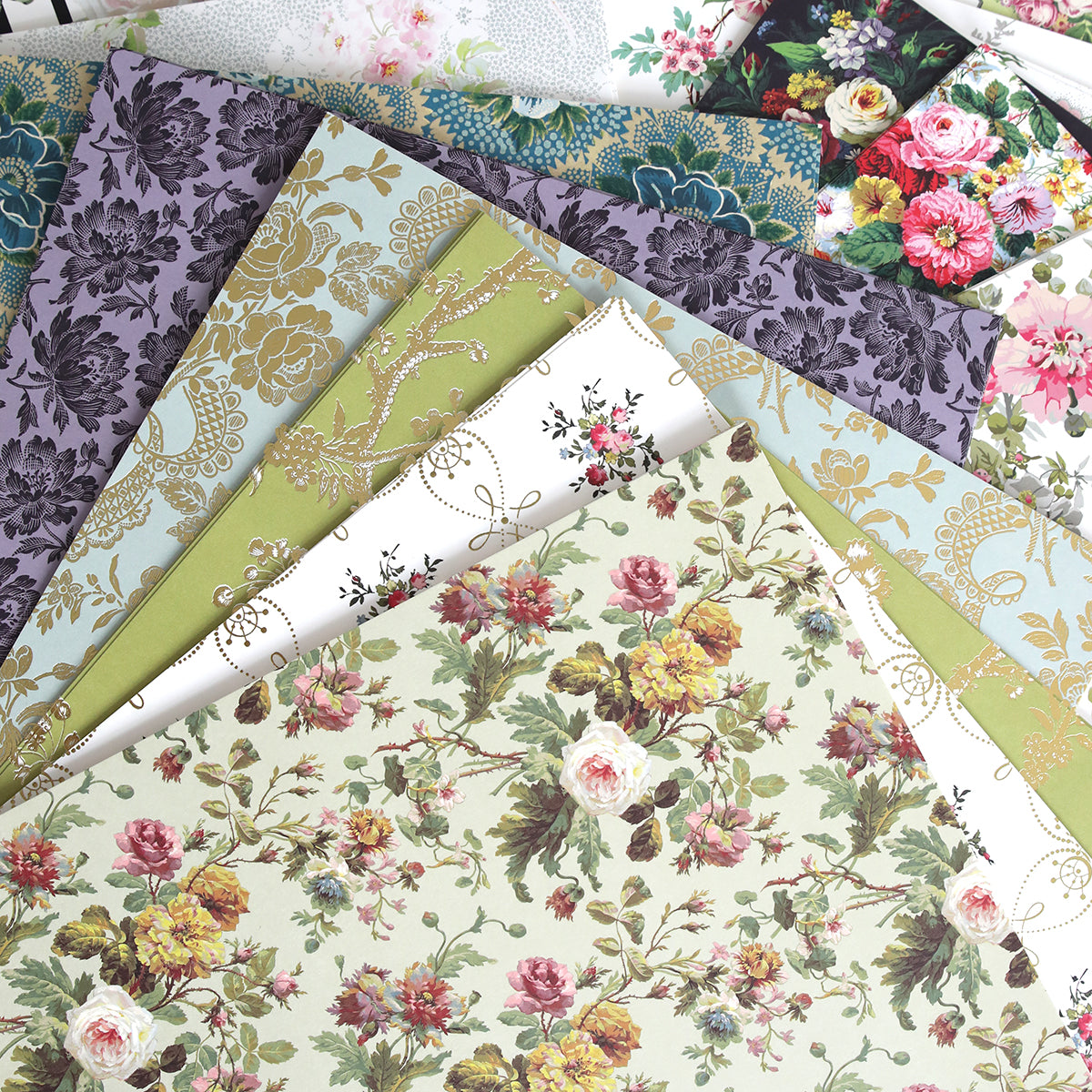 The Floral Paper Anthology features a fan-shaped selection of decorative papers with floral patterns in diverse colors and designs, ideal for elevating scrapbooks or crafting beautiful handmade floral cardstock cards.