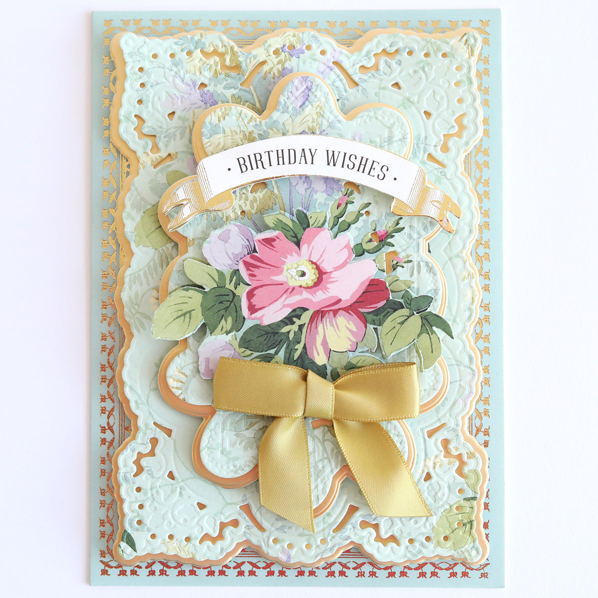 The Floral Paper Anthology birthday card features layered floral cardstock, a "Birthday Wishes" banner, and a gold bow on ornate embossed paper. Ideal for scrapbooking or as a cherished handmade card.