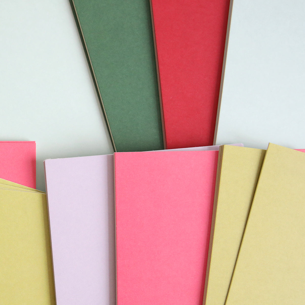 The Luxury Solid Cardstock collection features vibrant shades of red, green, pink, and yellow, arranged in an overlapping pattern that's perfect for die-cutting projects.