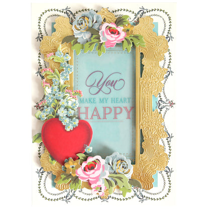 The Smitten Sentiments Rub On Transfers feature a beautiful Valentine's Day design with a gold frame, floral embellishments, and a red heart accent. The text "You make my heart happy" is showcased on a blue background.