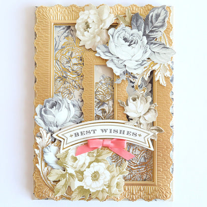 A greeting card named "Glorious Foil Rub Ons Gold" features white roses surrounded by embossed gold borders with gold foil transfers and a "Best Wishes" banner showcased with a pink bow at the bottom.