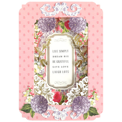 The Tunnel Card Making Kit features a decorative card with a floral border on a pink background. The central text reads: "Live simply, dream big, be grateful, give love, laugh lots." Ideal for crafting enthusiasts and personalized touches.