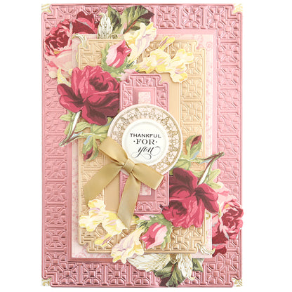 A layered card featuring pink floral die-cuts, a geometric border created with the Elegant Frames and Borders Die Set, and a circular “Thankful for you” tag finished with a ribbon bow.