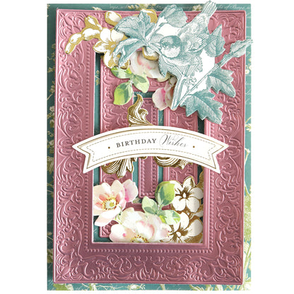 A decorative birthday card featuring the Birthday Present Scroll 3D Concentric Frame Dies, designed with embossed pink borders, floral details, a bird illustration, and a "Birthday Wishes" banner for an elegant, detailed finish.