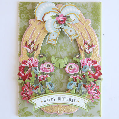 A decorative birthday card with a pastel bow, gold frame, and pink-red flowers plus “Happy Birthday” banner—perfect for pairing with Phoebe Die Cut Embellishments.