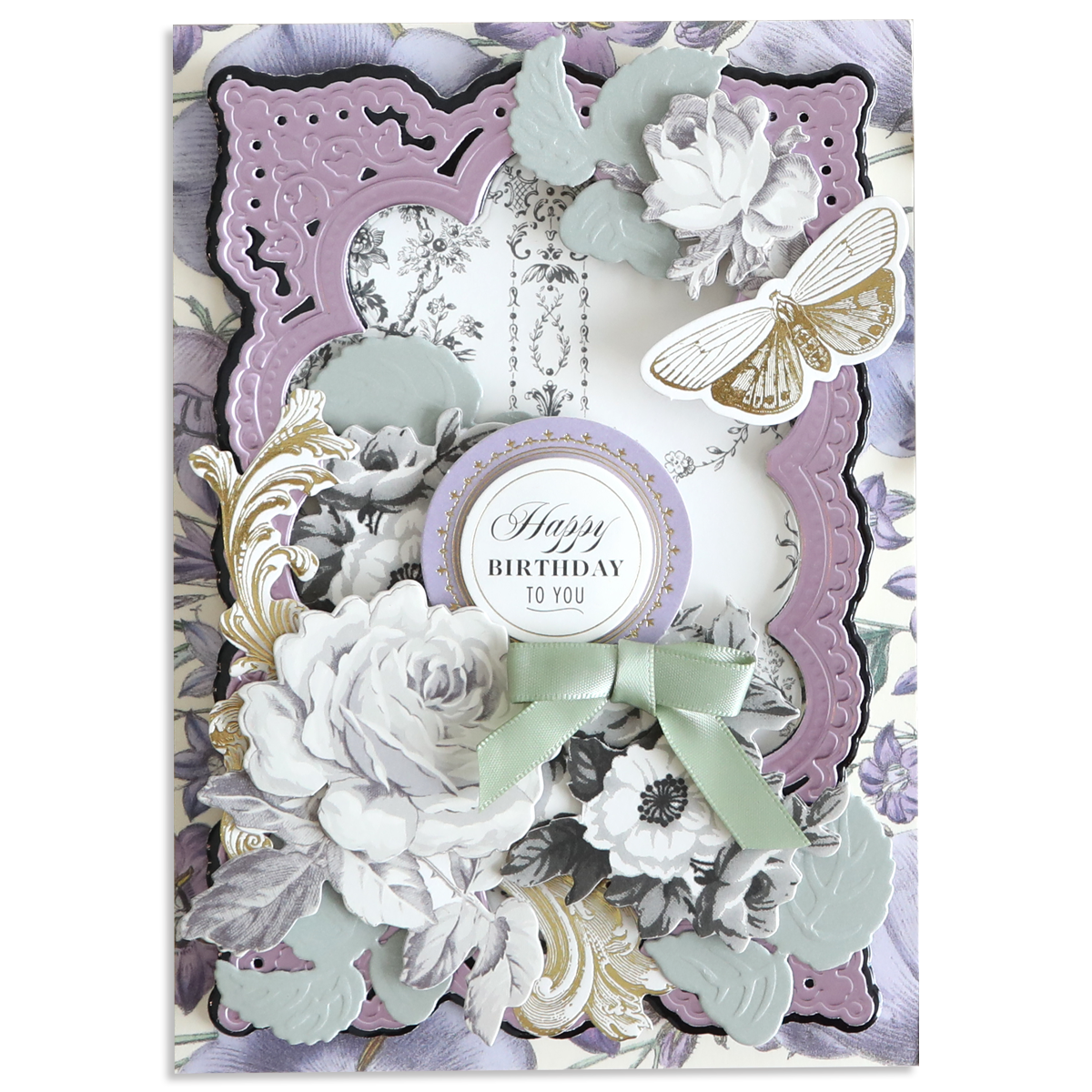 Decorative birthday card featuring Faded Rose Die Cut Embellishments, layered vintage florals, a gold and white butterfly, a round "Happy Birthday to You" message, craft accents, and a green ribbon bow at the center.