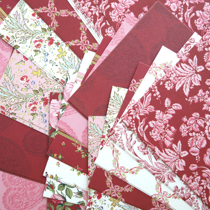 Heartfelt Cardstock features rectangular, double-sided sheets in red, pink, and white tones with floral and decorative patterns, arranged in an overlapping display.