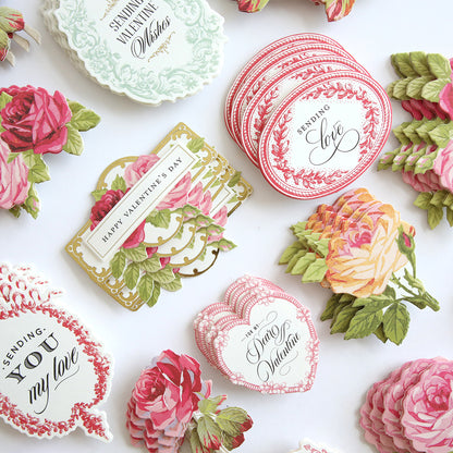 Heartfelt Stickers, assorted vintage-style Valentine's Day cards, and romantic floral cut-out decorations arranged on a white surface.