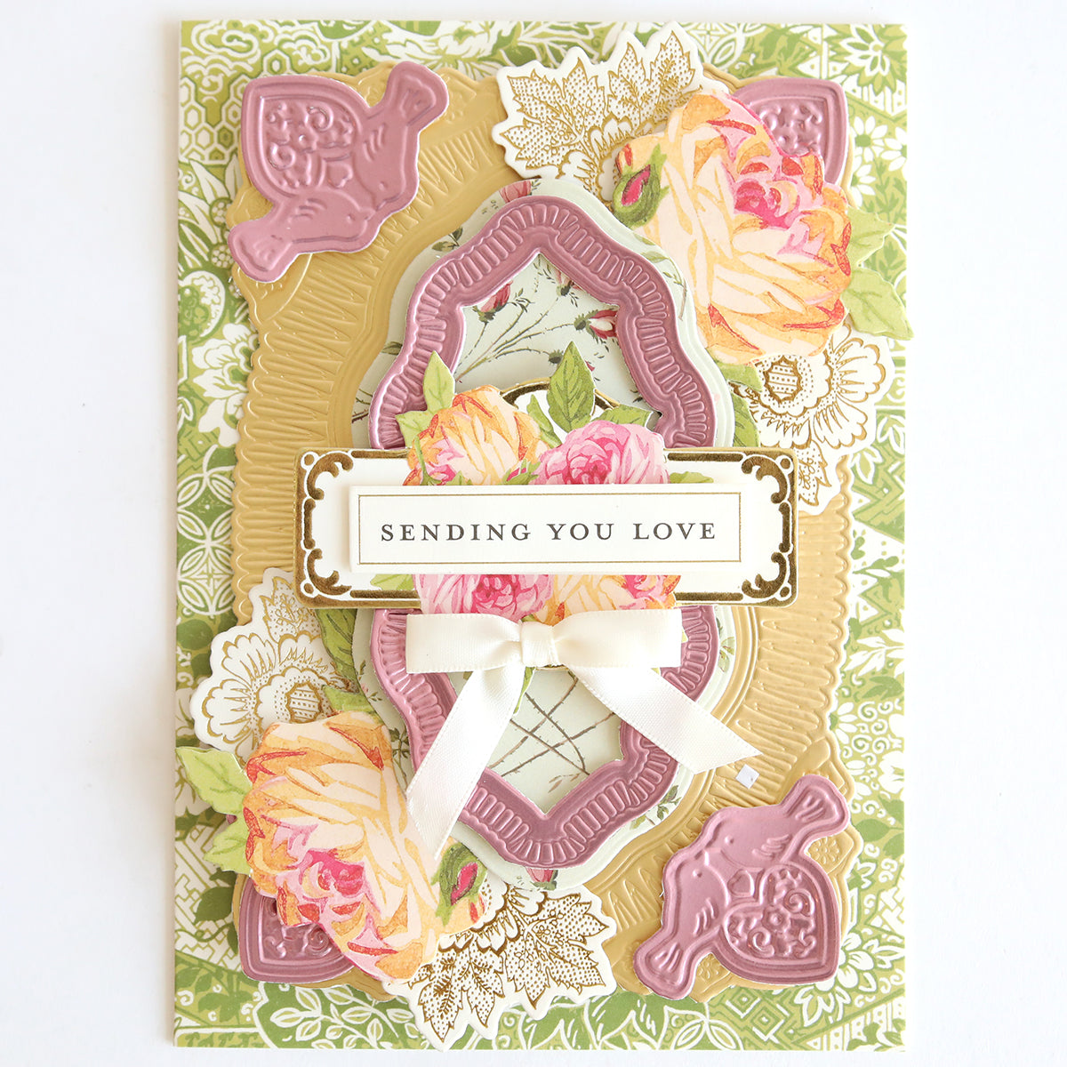 A decorative card featuring Heartfelt Stickers, romantic florals, gold accents, a white bow, and a "SENDING YOU LOVE" label on the front.