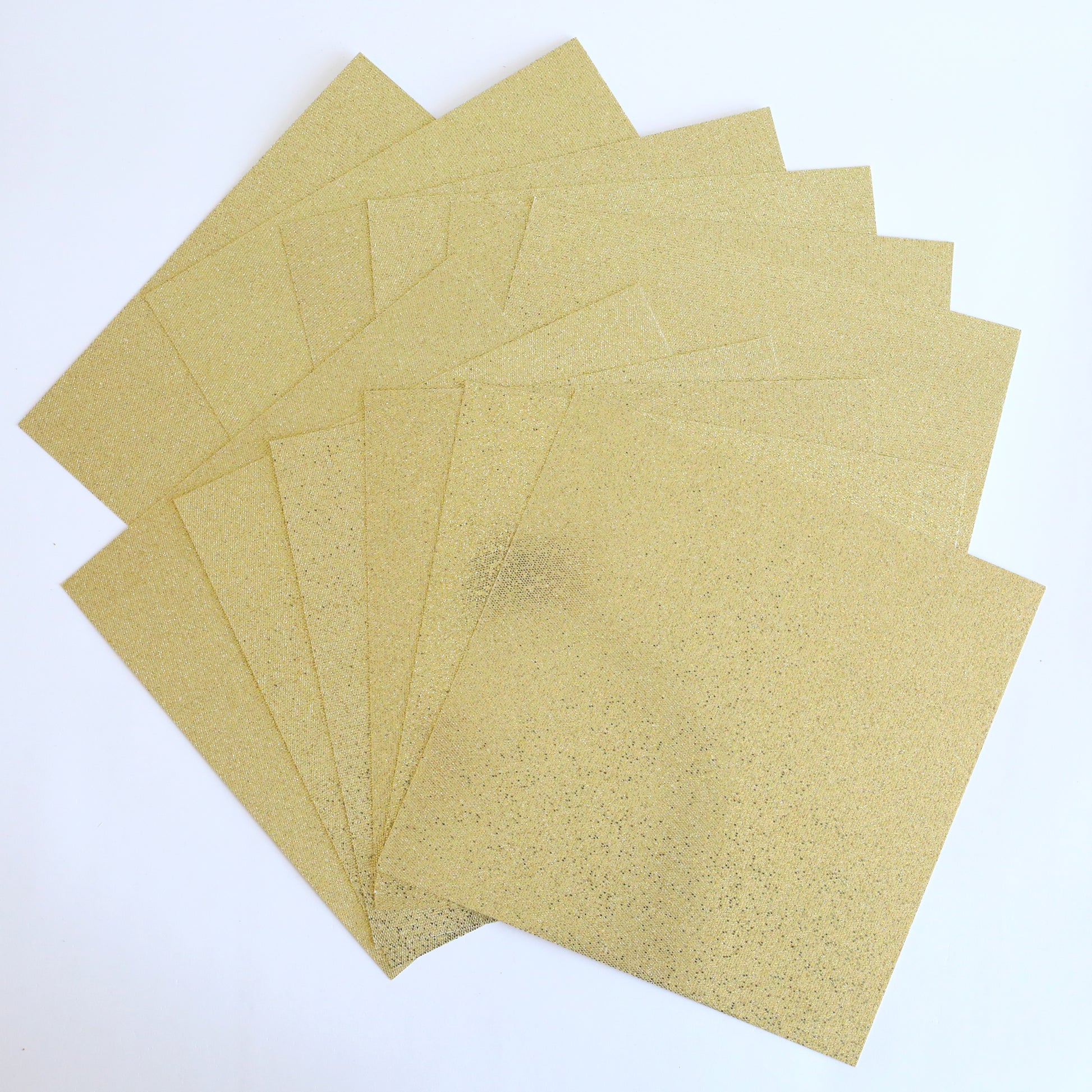 A stack of Diamond Glitter 12x12 Cardstock 12 sheets, ideal for scrapbook supplies, is fanned out on a white background.