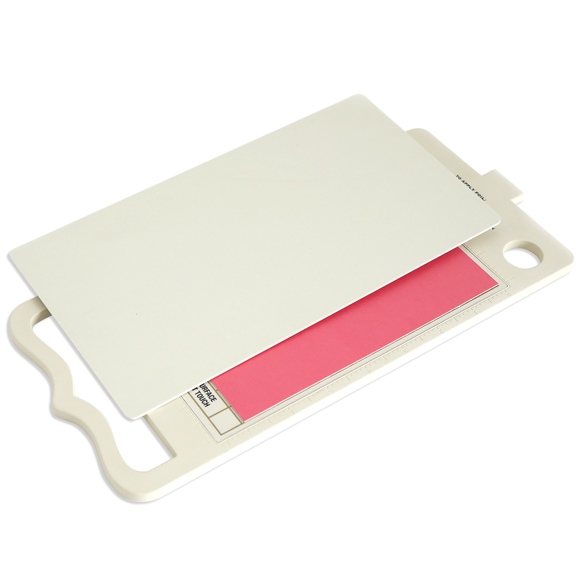 A white cutting board with a handle, partially covered by a white plastic sheet and showing a pink printed label underneath, is perfect for use with the Empress Gild Hot Foil Machine and its heat-activated foiling system.