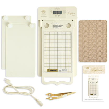 The Empress Gild Hot Foil Machine kit features a digital display, grid plate, spatula tool, power cord, two plates, patterned notebook, and instruction sheet, all arranged on a white background.