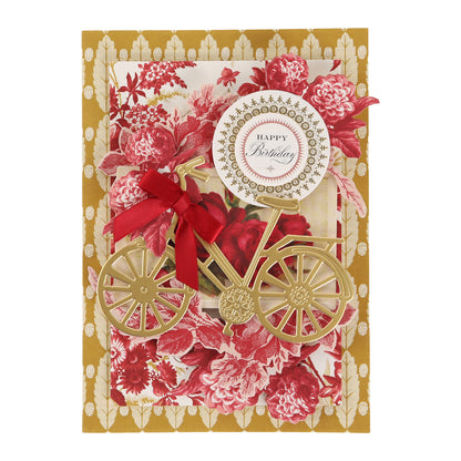 Greeting card featuring a gold bicycle, red ribbon, and a floral background in rich red and gold hues, topped with a “Happy Birthday” message. Crafted using the Fleur Rouge Papercrafting Kit with Dies, this vintage-inspired project showcases elegant details and decorative die cuts for an extra-special touch.