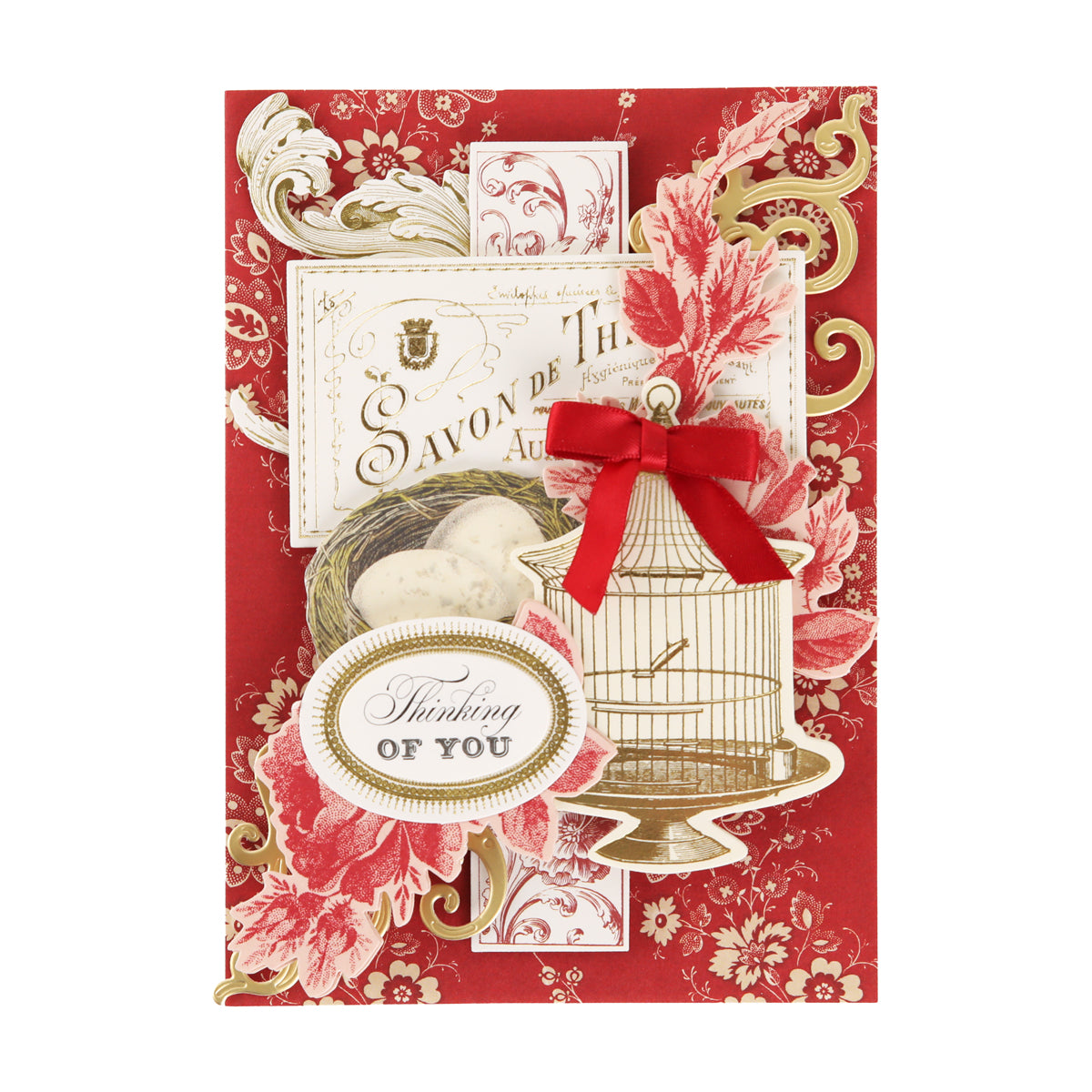 A greeting card featuring an elegant red and gold floral background created with decorative dies from the Fleur Rouge Papercrafting Kit with Dies, adorned with a birdcage, a nest, a red bow, and finished with a “Thinking of You” sentiment for a touch of vintage-inspired style.