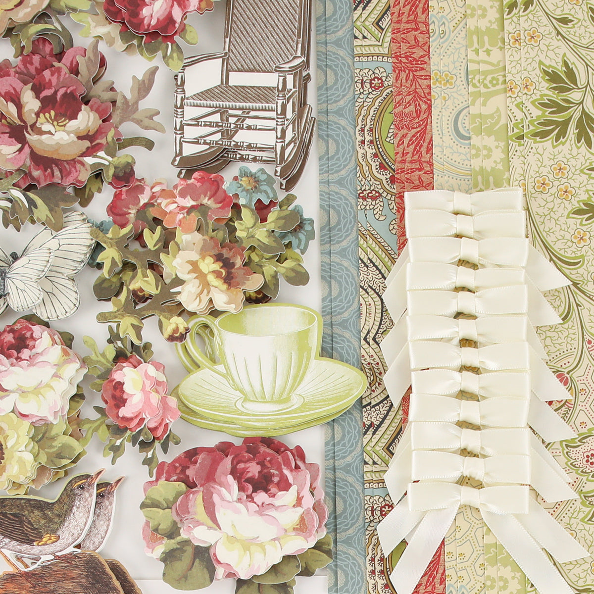 Haven Papercrafting Kit with Dies including floral, bird, teacup, and rocking chair coordinating dies, patterned paper sheets, and a strip of white satin bows.