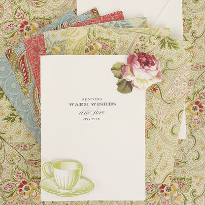 A vintage greeting card created with the Haven Papercrafting Kit with Dies, featuring “Sending warm wishes and love to you” text, a die-cut floral embellishment, a teacup, and patterned paper envelopes.
