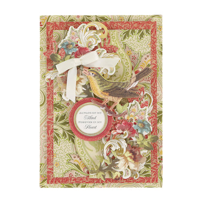 A handmade greeting card created with a Haven Papercrafting Kit with Dies, featuring a bird, floral cutouts, a white ribbon bow, and a sentiment reading, “Always on my mind, forever in my heart.”