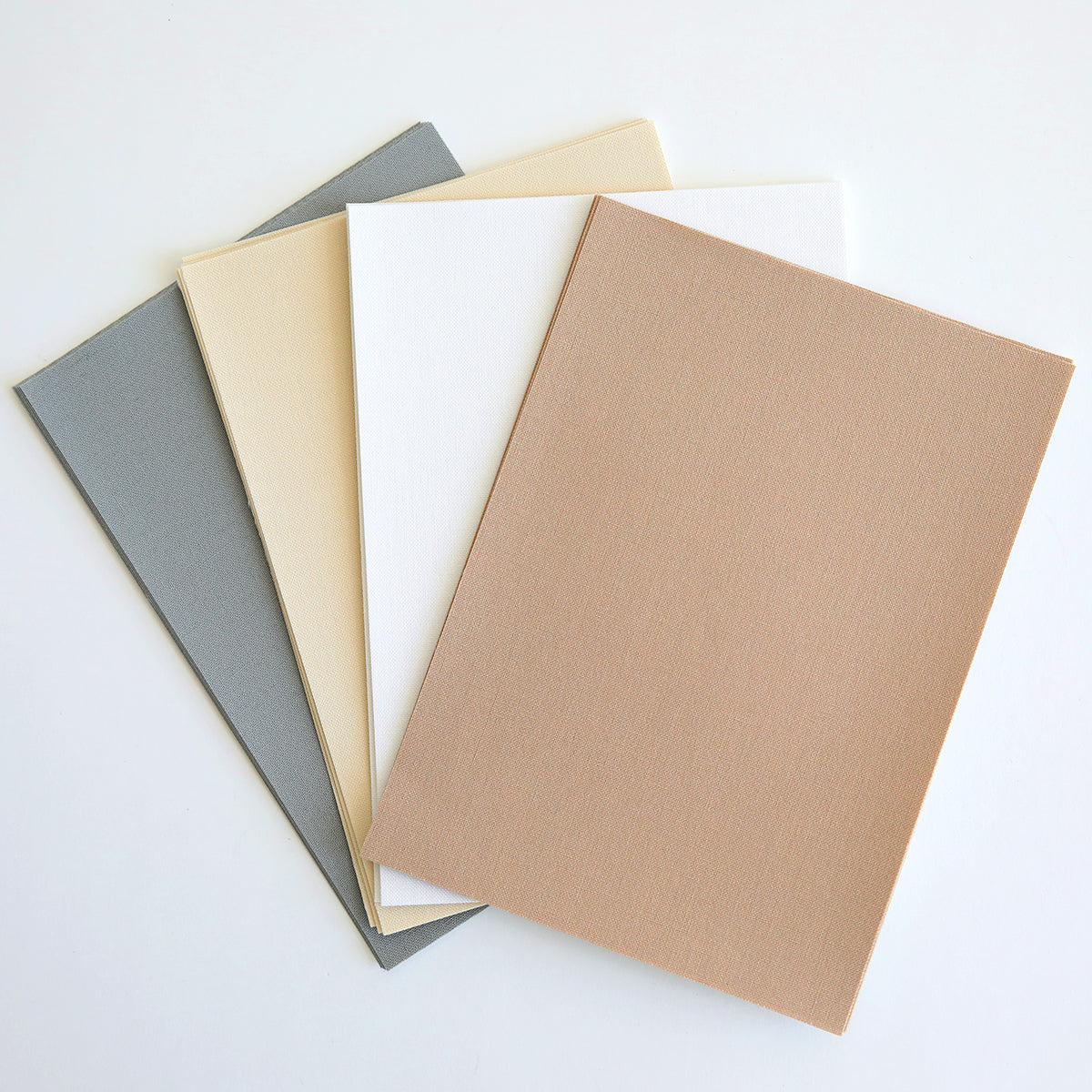 Fabric Card Layers Neutral features four textured rectangular sheets in gray, cream, white, and light brown arranged in a fan on a white surface—ideal as neutral card layers for handmade cards.