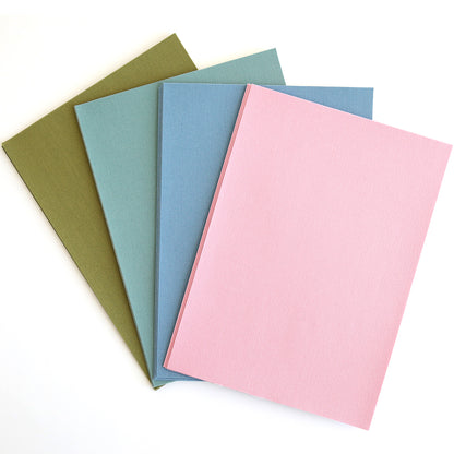 Four closed Fabric Card Layers Antique in olive green, teal, blue, and pink are fanned out on a white surface—perfect for inspiring your next card design or paper crafting project.