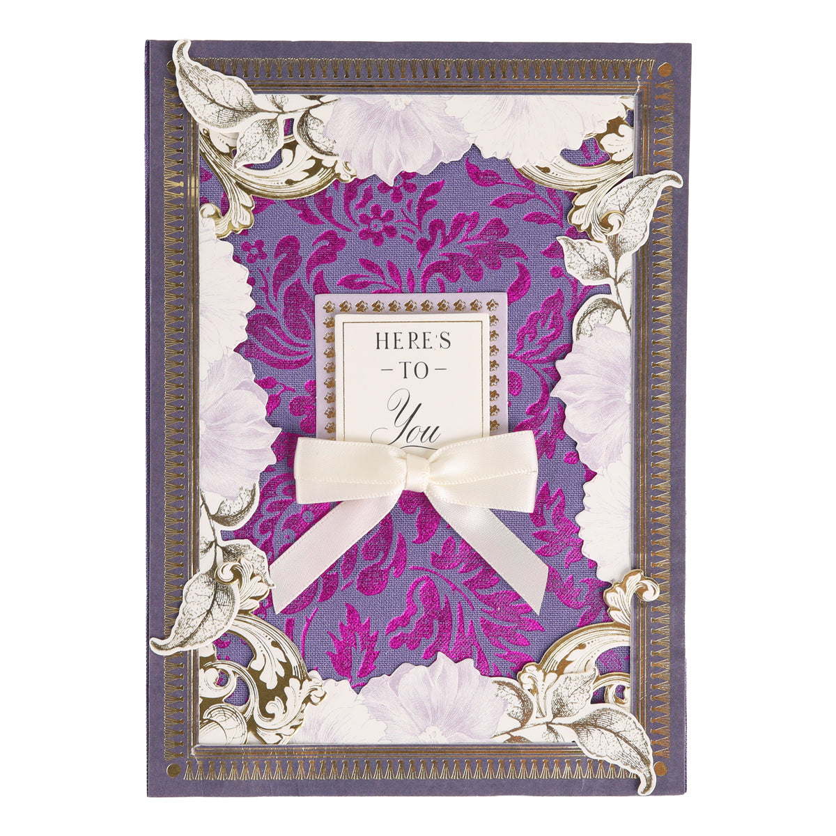 Introducing Bright Fabric Card Layers: a decorative greeting card featuring fabric layers with vibrant purple floral patterns, elegant gold accents, a charming white bow, and the heartfelt message “HERE’S TO You” in the center—perfect for scrapbooking or card making enthusiasts.